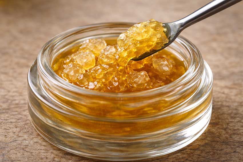 Solventless cannabis rosin being scooped from a glass jar at Huff and Puff Dispensary